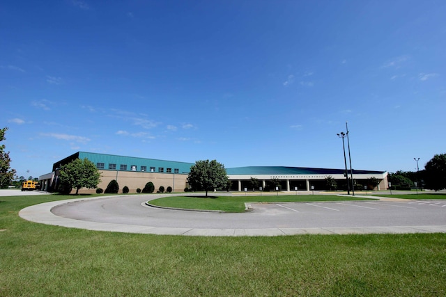 exterior space featuring uncovered parking and a lawn