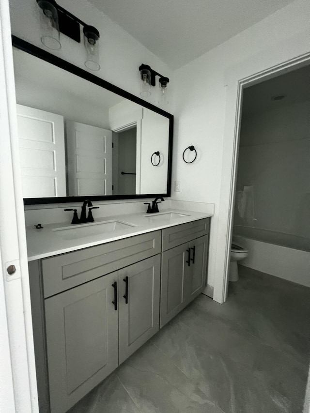 full bath featuring a sink, toilet, and double vanity