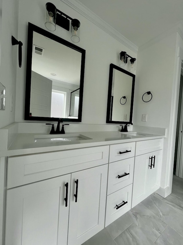 bathroom with marble finish floor, crown molding, double vanity, visible vents, and a sink