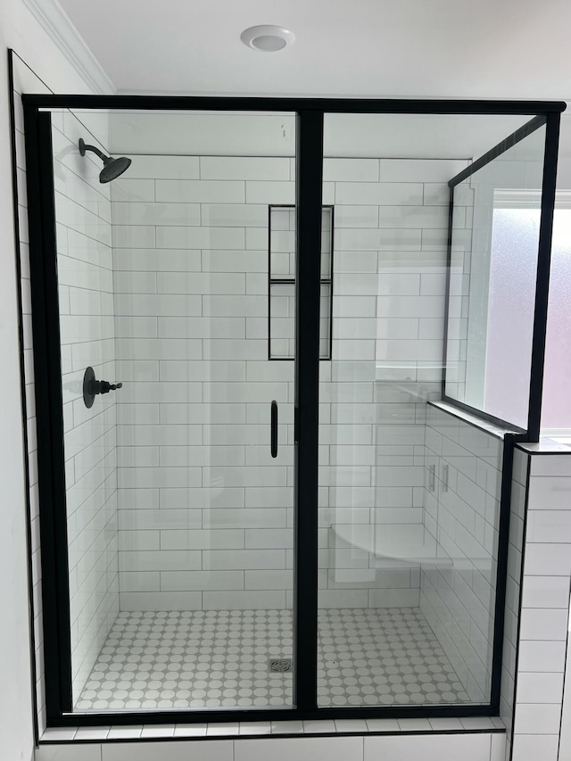 full bath with ornamental molding and a stall shower