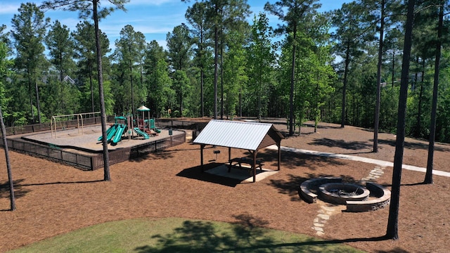 community playground featuring an outdoor fire pit and fence