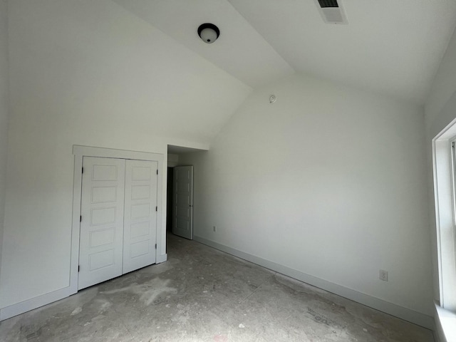 interior space featuring visible vents, vaulted ceiling, and baseboards