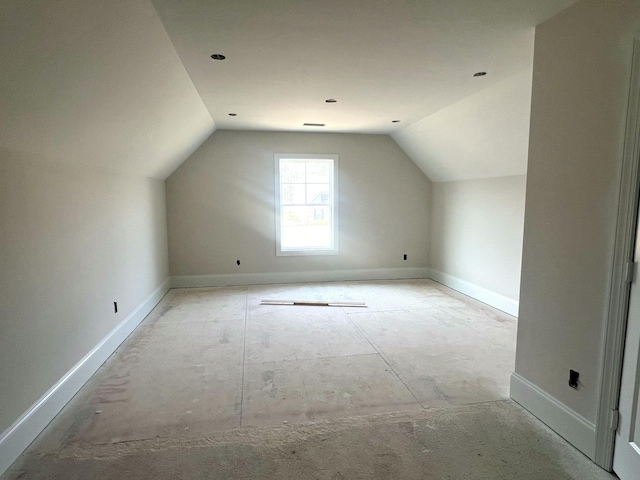 additional living space featuring vaulted ceiling and baseboards