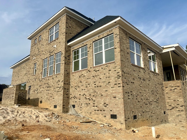 view of side of home featuring crawl space and brick siding