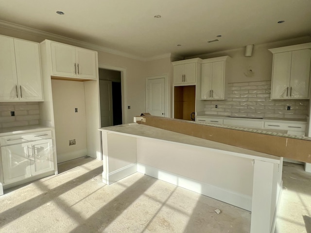 kitchen featuring white cabinetry, tasteful backsplash, ornamental molding, and a center island