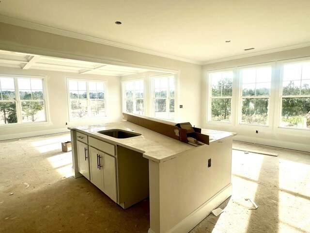 kitchen featuring sink, beam ceiling, coffered ceiling, light stone counters, and ornamental molding