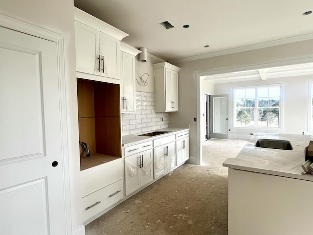 kitchen with sink, black electric cooktop, ornamental molding, decorative backsplash, and white cabinets