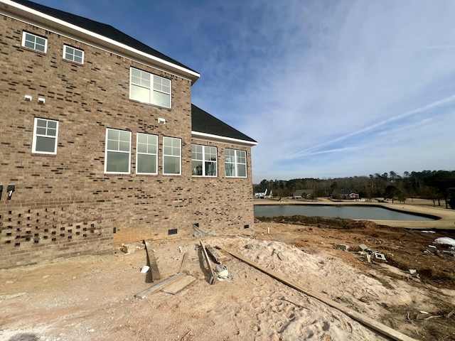 view of side of property featuring a water view and brick siding