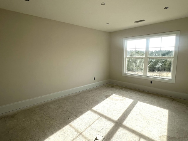 unfurnished room featuring baseboards and visible vents