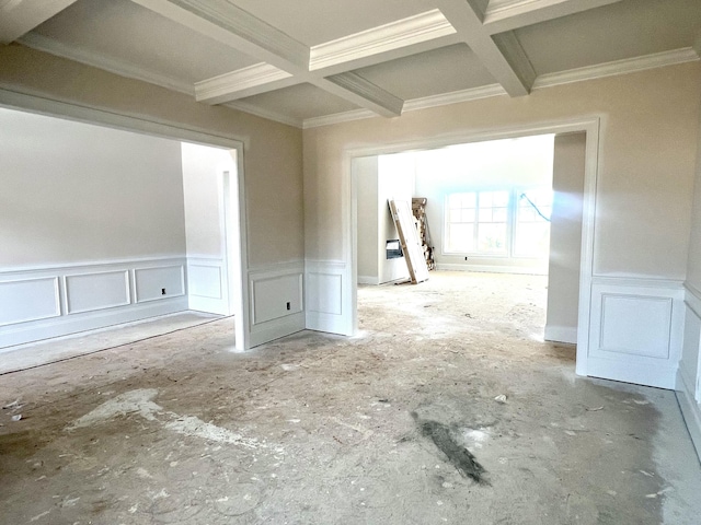 spare room featuring ornamental molding, coffered ceiling, beam ceiling, and a decorative wall