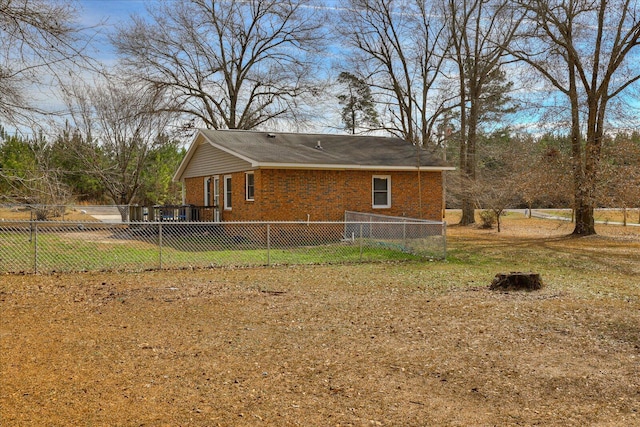 view of home's exterior with fence private yard, brick siding, and a lawn