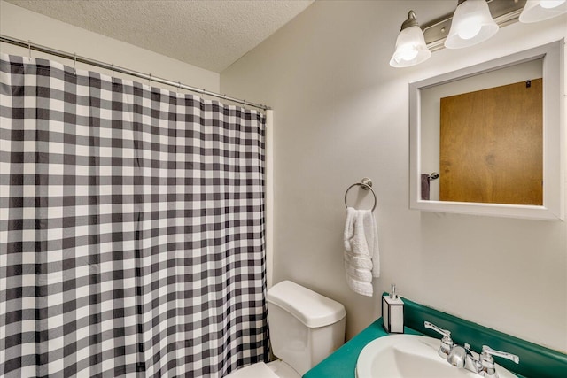 bathroom with toilet, a sink, and a textured ceiling