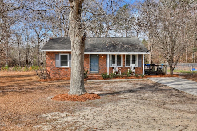 view of front facade featuring brick siding and a porch