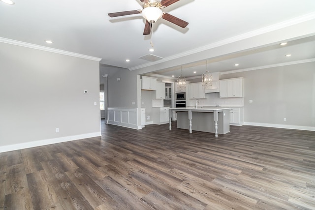 unfurnished living room featuring crown molding, dark hardwood / wood-style flooring, ceiling fan, and sink