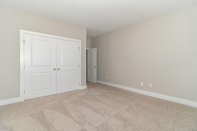 unfurnished bedroom featuring carpet flooring and a closet