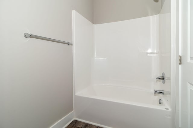 bathroom featuring wood-type flooring and bathtub / shower combination