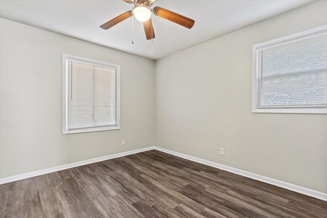 spare room featuring dark wood-type flooring, ceiling fan, and a healthy amount of sunlight