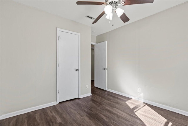 unfurnished bedroom featuring ceiling fan and dark wood-type flooring