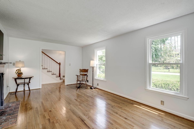 3103 Holly Haven Dr, Augusta, GA 30907 - sitting room featuring stairway, wood finished floors, a textured ceiling, and a brick fireplace