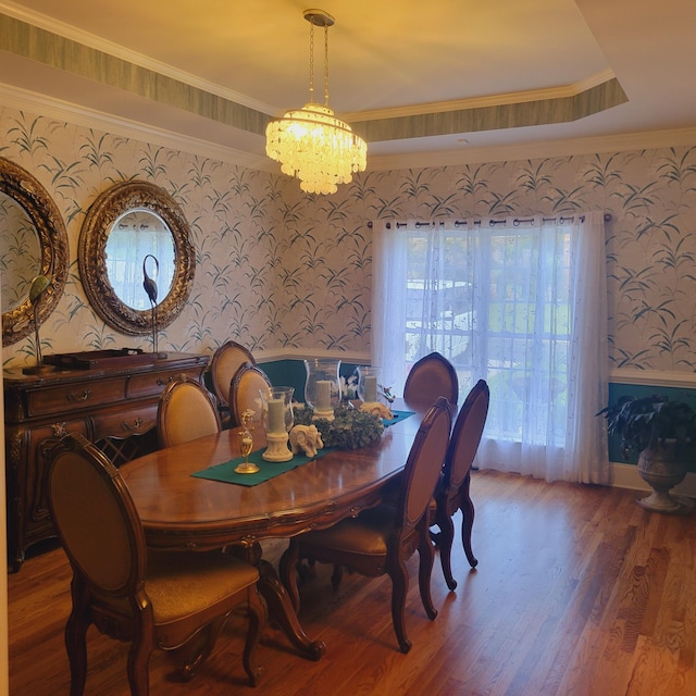 dining area featuring hardwood / wood-style floors, ornamental molding, and a chandelier