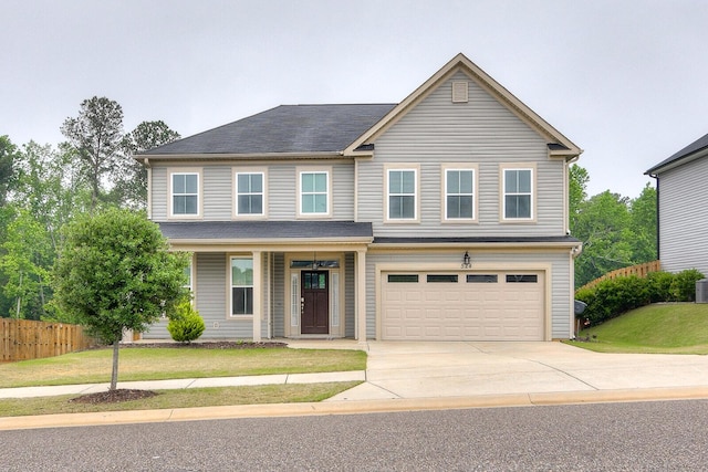 traditional home with a garage, concrete driveway, and covered porch