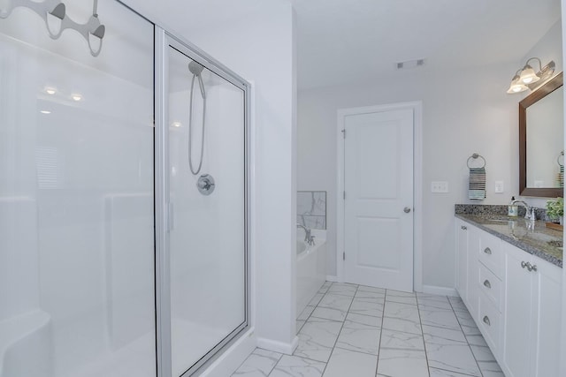 full bath featuring marble look tile flooring, a stall shower, a garden tub, vanity, and baseboards