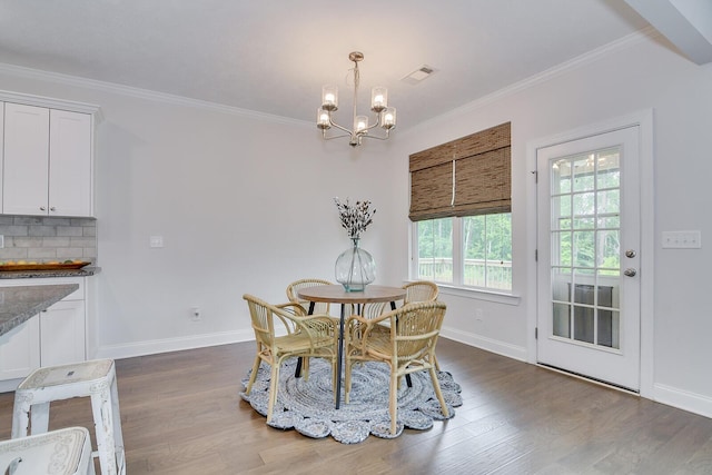 dining space featuring a chandelier, baseboards, dark wood-style floors, and crown molding