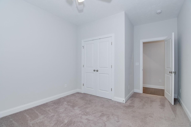 unfurnished bedroom featuring carpet floors, a closet, and baseboards