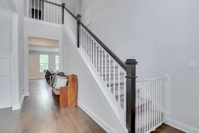 stairs with wood finished floors and baseboards