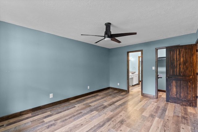 221 Creek View Cir, Martinez, GA 30907 - unfurnished bedroom with wood finished floors, a walk in closet, a textured ceiling, and a ceiling fan