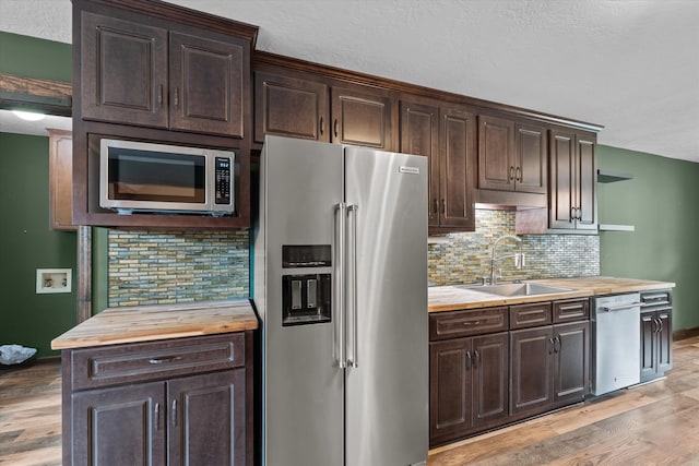 221 Creek View Cir, Martinez, GA 30907 - kitchen with stainless steel appliances, wood counters, dark brown cabinetry, light wood-type flooring, and backsplash