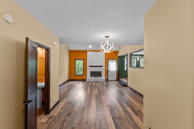 221 Creek View Cir, Martinez, GA 30907 - unfurnished living room featuring a chandelier, dark wood-style flooring, a brick fireplace, and a textured ceiling