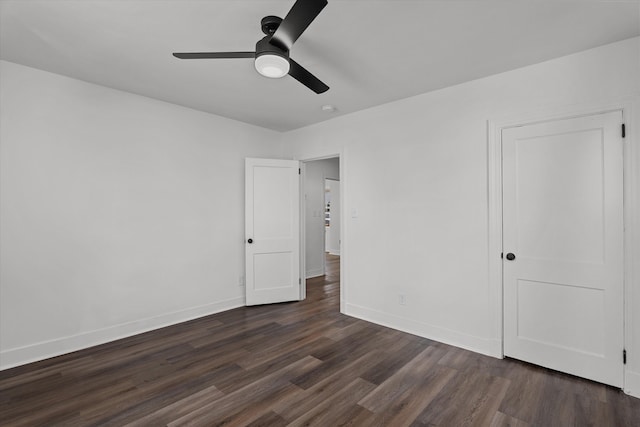 unfurnished bedroom featuring ceiling fan, dark wood-style flooring, and baseboards