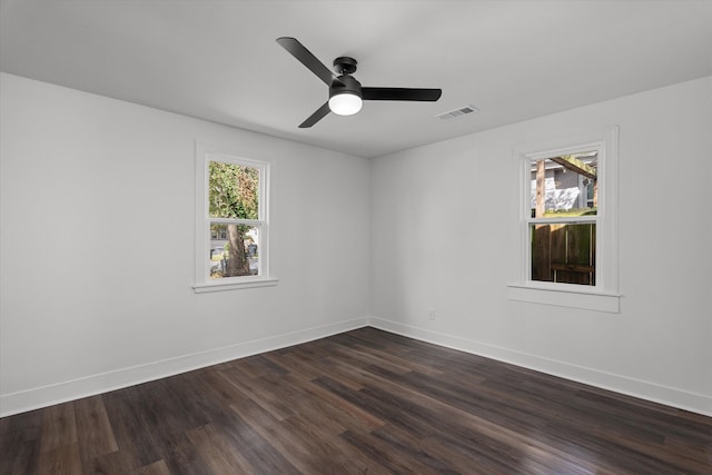 unfurnished room featuring dark wood-style floors, visible vents, ceiling fan, and baseboards