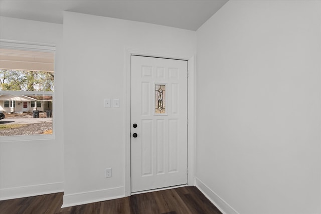 foyer with dark wood-style flooring and baseboards