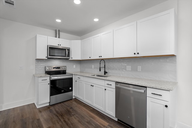 kitchen with dark wood-style floors, visible vents, decorative backsplash, appliances with stainless steel finishes, and a sink