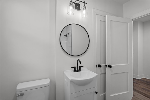 bathroom featuring wood finished floors, vanity, toilet, and baseboards