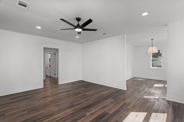 unfurnished room featuring baseboards, visible vents, dark wood-type flooring, and recessed lighting