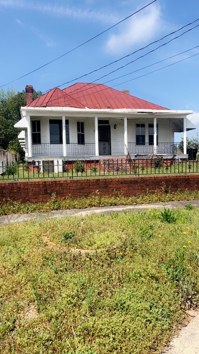 627 Montgomery St, Augusta, GA 30904 - view of front of home featuring metal roof, fence, covered porch, and a chimney