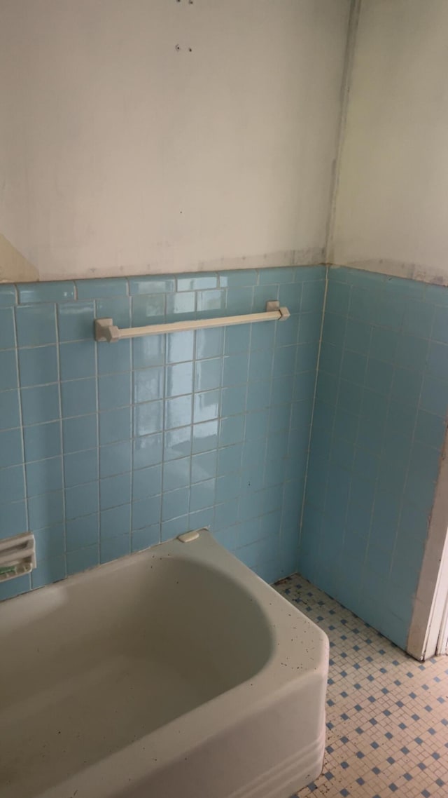 627 Montgomery St, Augusta, GA 30904 - full bath with tile walls, wainscoting, and a tub to relax in