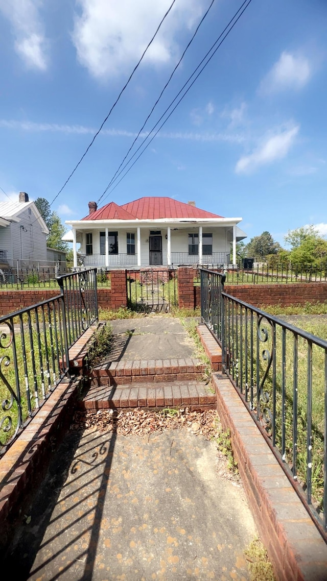 627 Montgomery St, Augusta, GA 30904 - back of property featuring a chimney, a porch, a fenced front yard, a standing seam roof, and metal roof