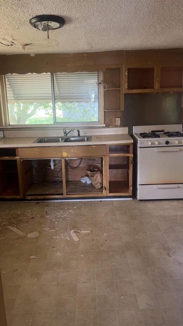 627 Montgomery St, Augusta, GA 30904 - kitchen with white gas range, a textured ceiling, and a sink