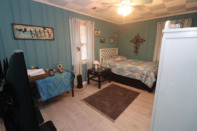 bedroom featuring ornamental molding, ceiling fan, and light hardwood / wood-style flooring