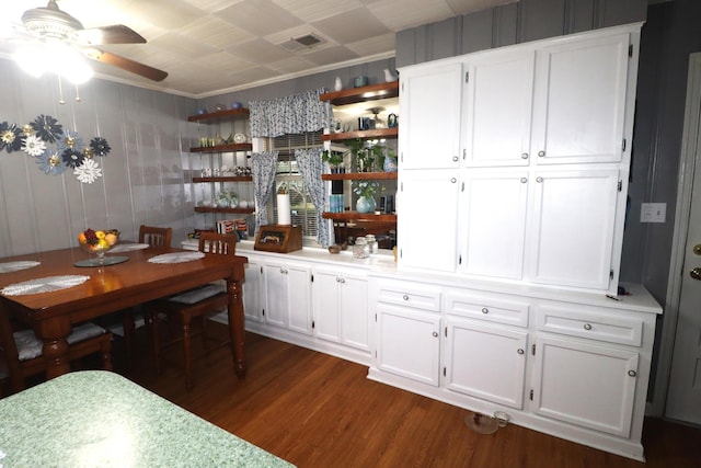 bar featuring white cabinets, ceiling fan, crown molding, and dark hardwood / wood-style floors