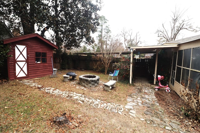 view of yard with a fire pit, a shed, and a sunroom