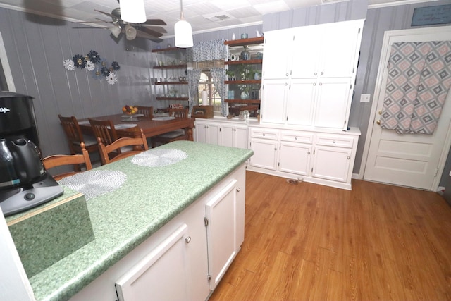 kitchen with white cabinets, ceiling fan, light hardwood / wood-style floors, and hanging light fixtures