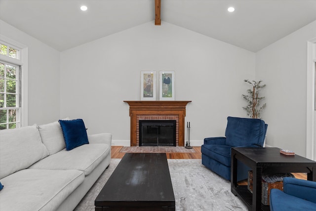 living room with vaulted ceiling with beams, a brick fireplace, recessed lighting, and wood finished floors