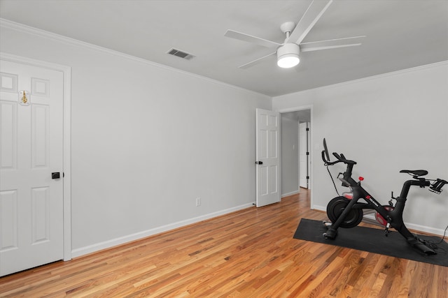 workout room with baseboards, ornamental molding, light wood-type flooring, and visible vents