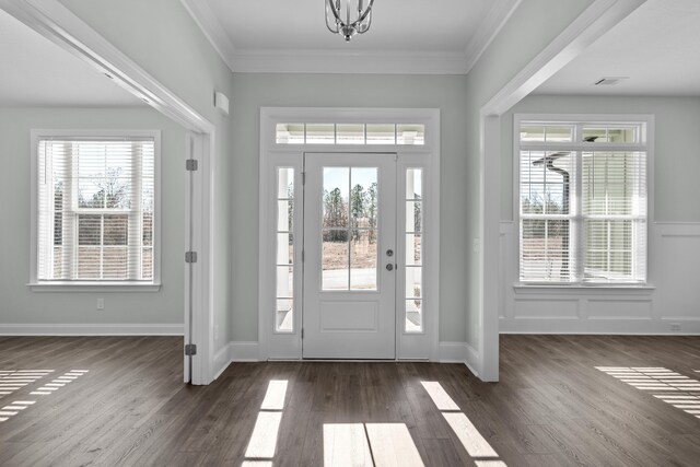 entrance foyer with crown molding, dark hardwood / wood-style floors, and a notable chandelier