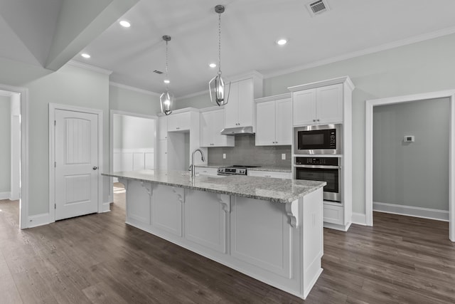 kitchen with a kitchen island with sink, a breakfast bar area, light stone counters, white cabinetry, and stainless steel appliances